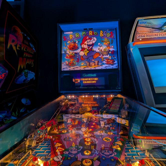 Bunt beleuchtetes Super Mario Bros.-Flippergerät in abgedunkeltem Raum.