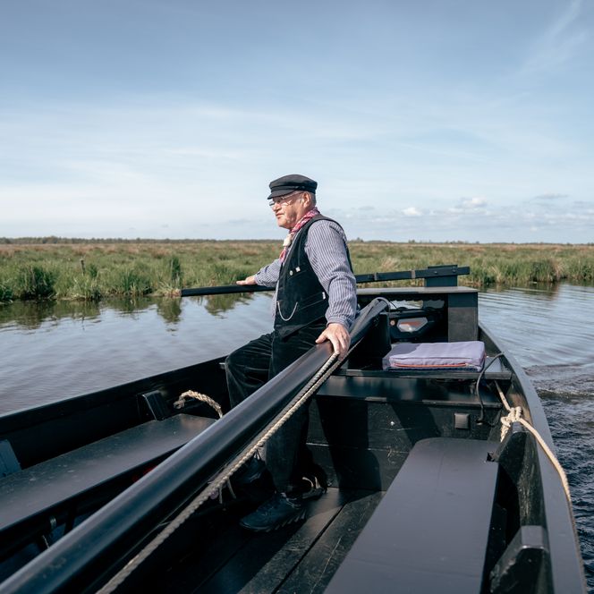 Ein Mann fährt mit einem traditionellen Torfkahn auf der Hamme durch das Teufelsmoor bei Worpswede.