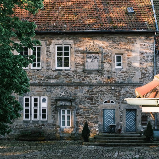 Historisches Steinhaus der Schaumburg mit Sprossenfenstern und roten Ziegeldächern.