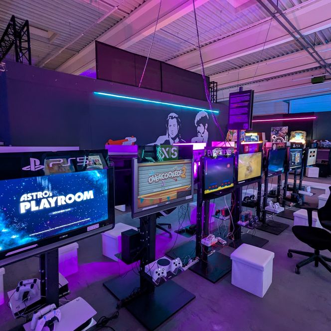 Gaming-Bereich mit mehreren Konsolen, Bildschirmen und LED-Beleuchtung im Videospielmuseum Hi-Score.