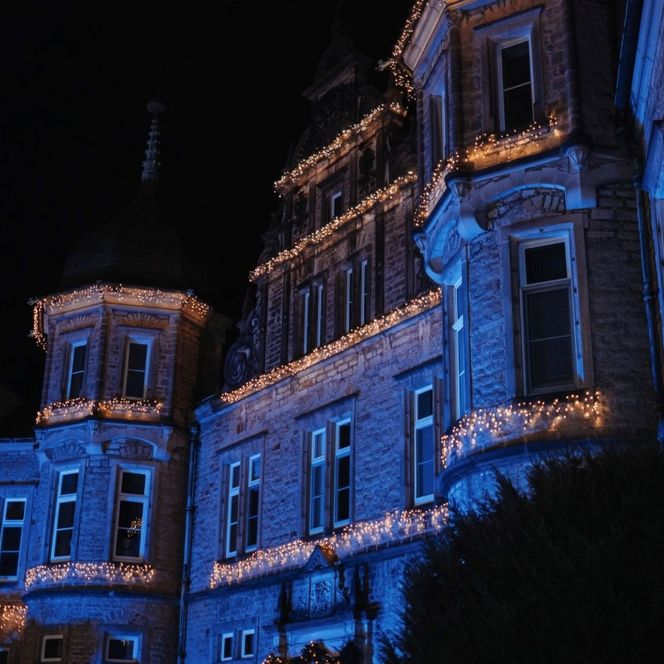 Beleuchtete Schlossfassade in Bückeburg mit festlicher Weihnachtsdekoration bei Nacht.