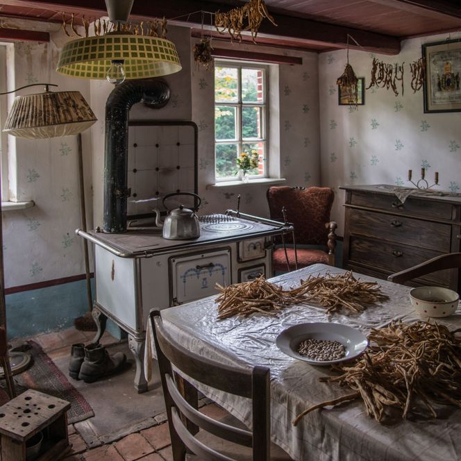 Wohnstube eines historischen Arbeiterhauses im Museumsdorf Cloppenburg mit altem Küchenofen.
