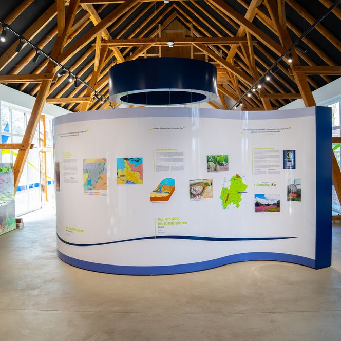 Innenraum der Natur- und Geoparkstation Theikenmeer mit Infotafeln und Holzgebälk.
