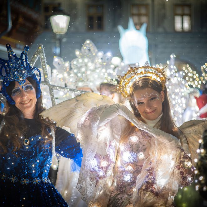 Lichteffekte erleuchten zwei Personen in fantasievollen Kostümen auf einer nächtlichen Veranstaltung.