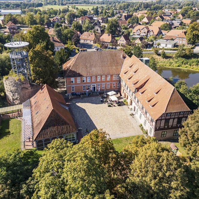 Luftbild von Schloss Bleckede mit Innenhof, Turmruine, Aussichtsplattform und Parkanlage.