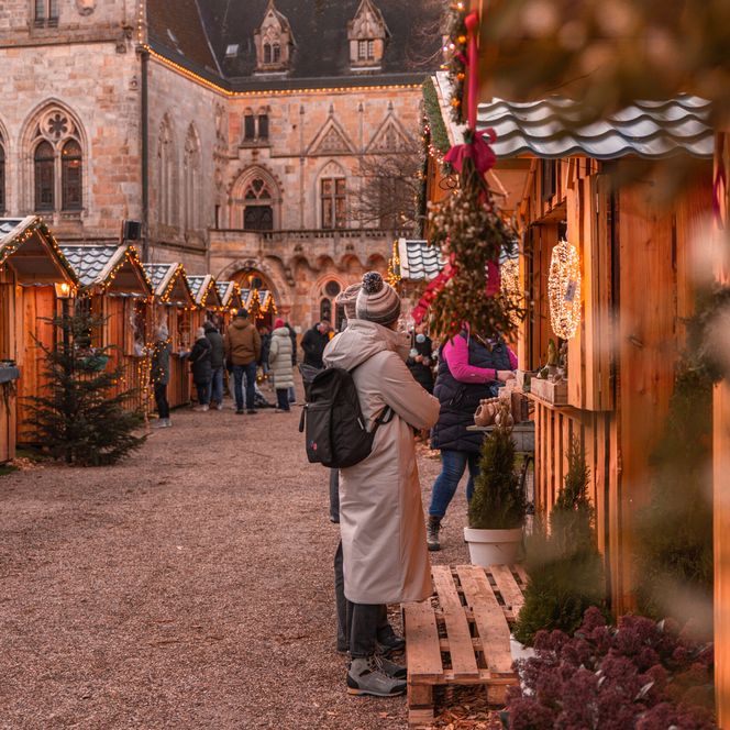 Besucher schlendern über den festlich geschmückten Weihnachtsmarkt vor der Burg Bentheim.