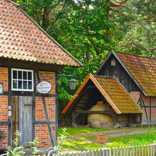 Eingangsbereich des Winser Museumshofs mit historischen Fachwerkhäusern und dem Museumsladen.