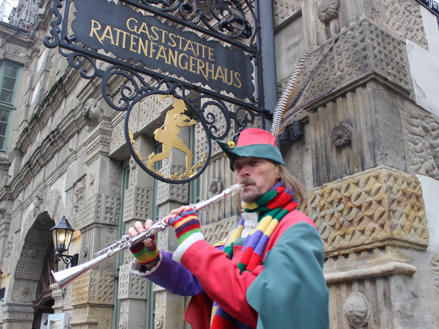 Der Rattenfänger von Hameln spielt Flöte vor dem Rattenfängerhaus