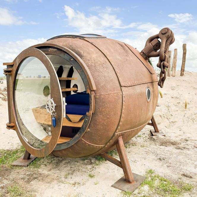 Een ankerboei omgebouwd tot ligplaats op het zandstrand.