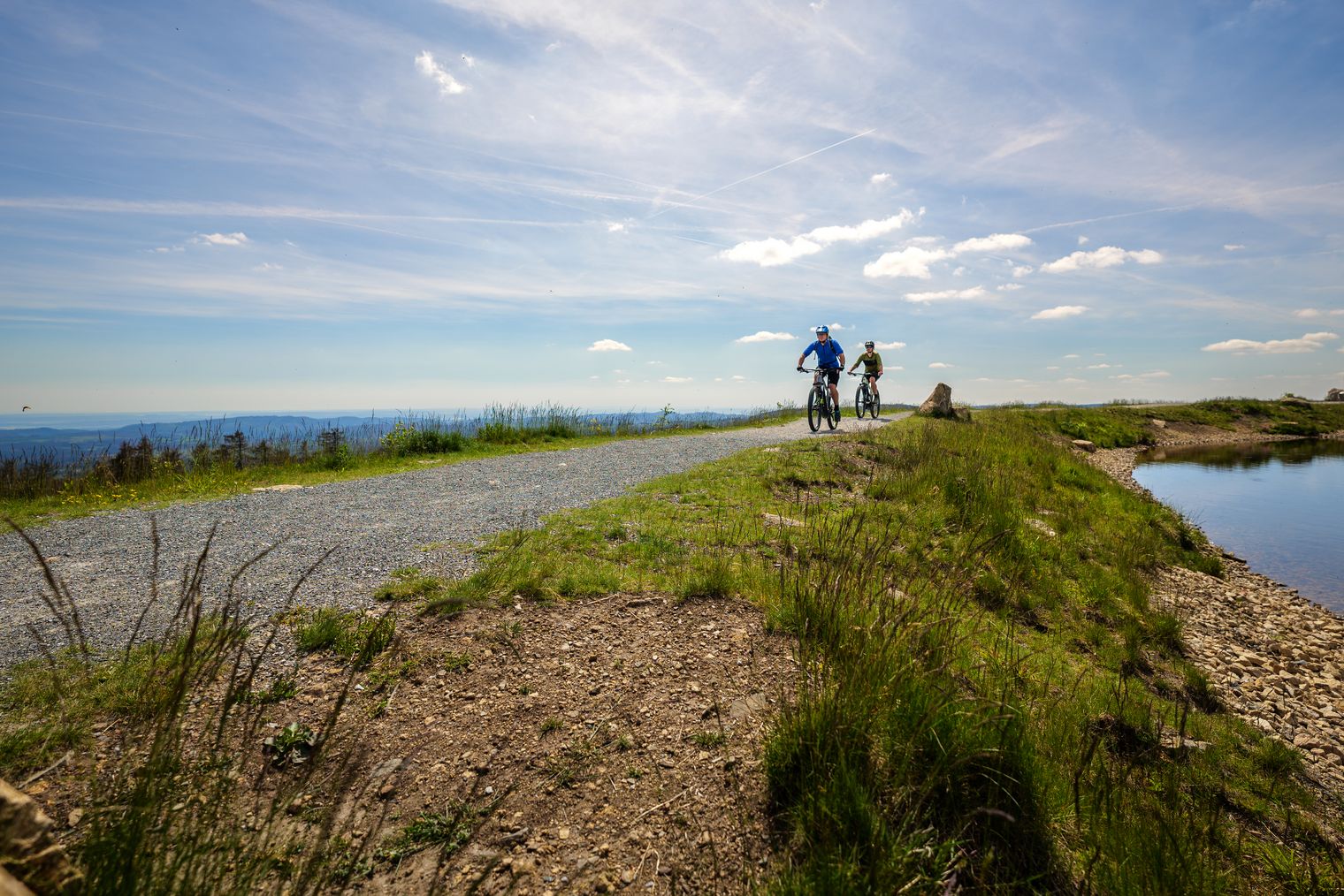 Mountainbiker fahren entlang eines Sees im Harz