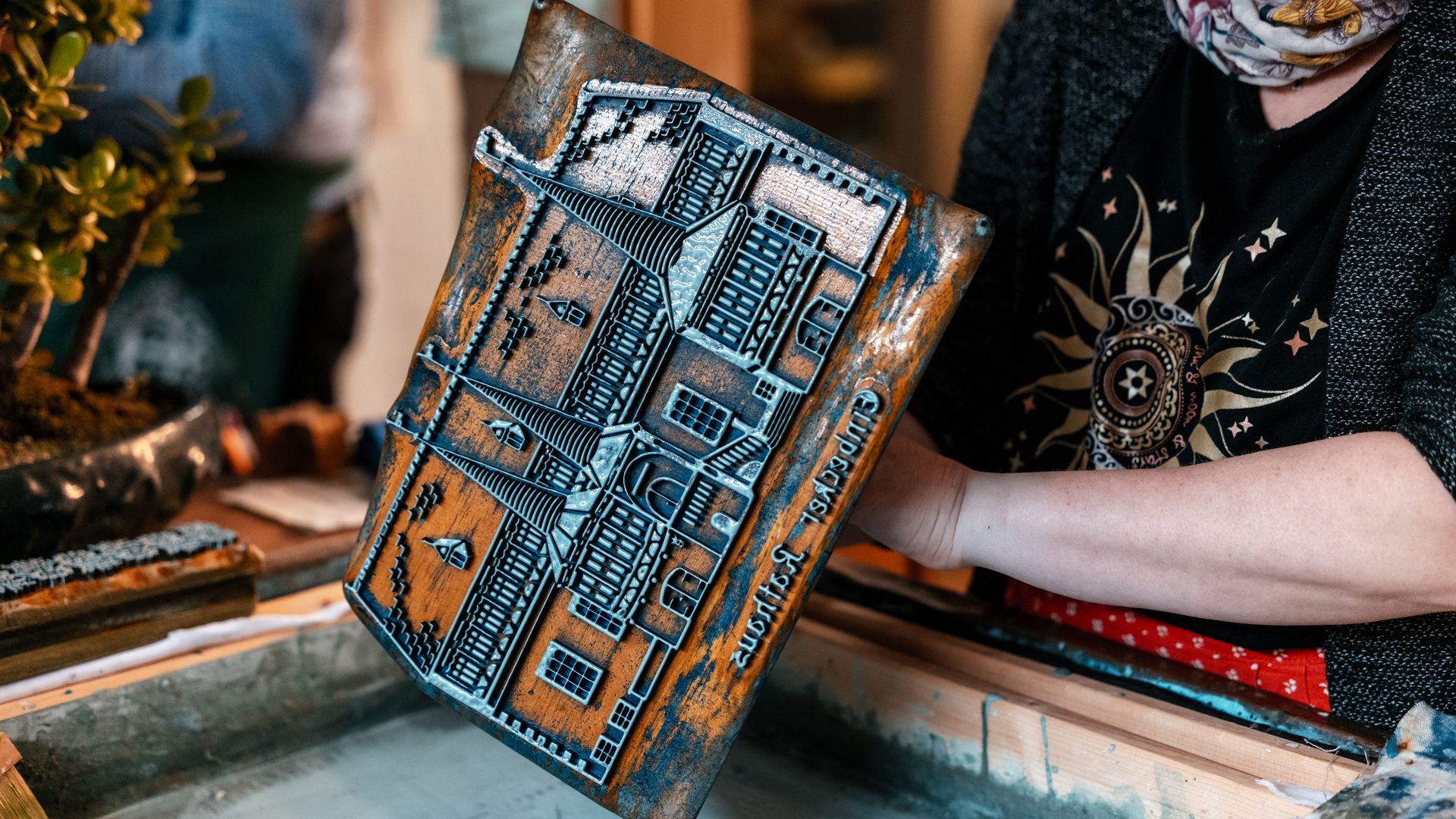 Person druckt mit Holzmodel auf Stoff bei einem Blaudruck-Workshop in Einbeck.