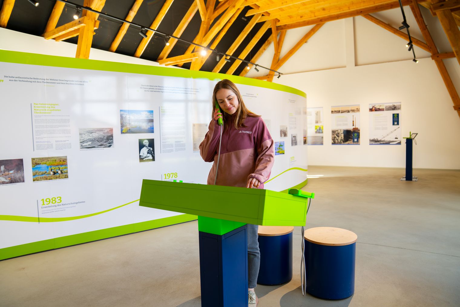 Besucherin an einer Hörstation in der Ausstellung zum Theikenmeer.