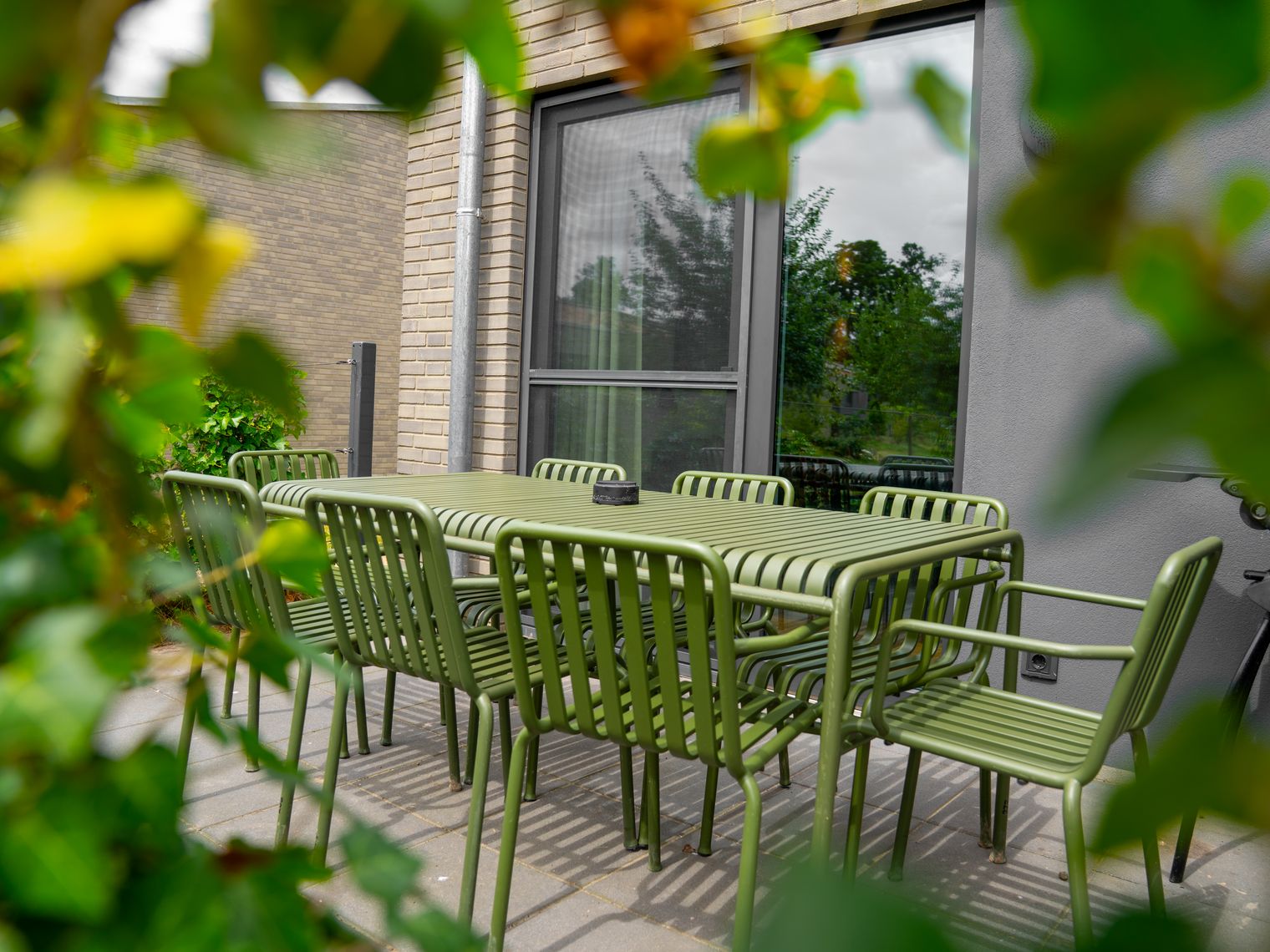 Grüne Sitzgruppe auf der Terrasse eines barrierefreien Ferienhauses.