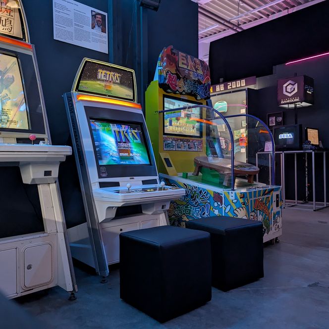 Arcade-Spielautomaten stehen in einem beleuchteten Raum.