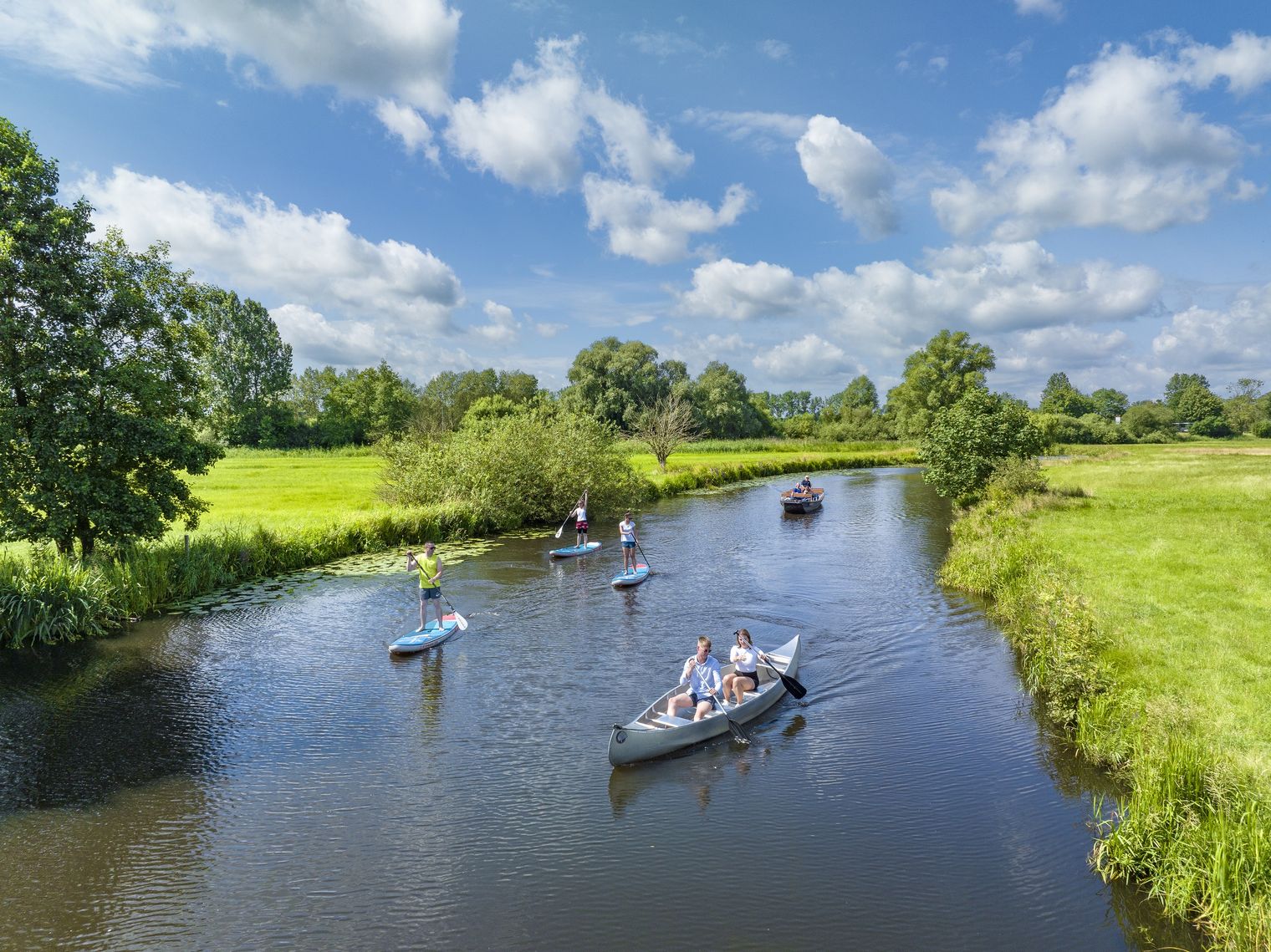 Stand Up Paddler und Kanufahrer bei Sonnenschein auf den Paddeltrails in Stade