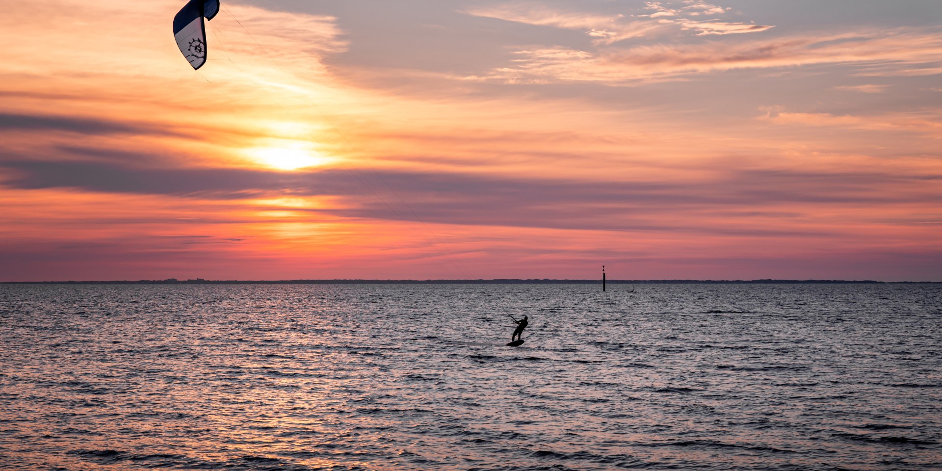 Kitesurfer auf dem Wasser im Sonnenuntergang., © Chris Hoppe