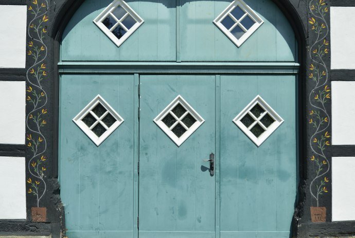 Eine rote Haustür im Osnabrücker Land in Niedersachsen., © TMN