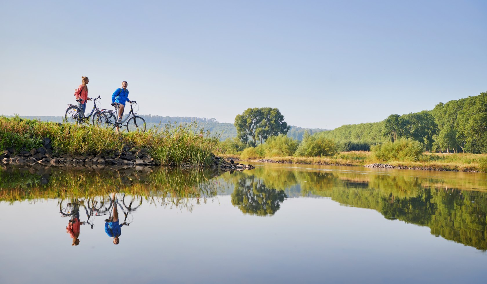 Paar mit Fahrrädern macht Pause an der Weser, © DZT/Jens Wegener