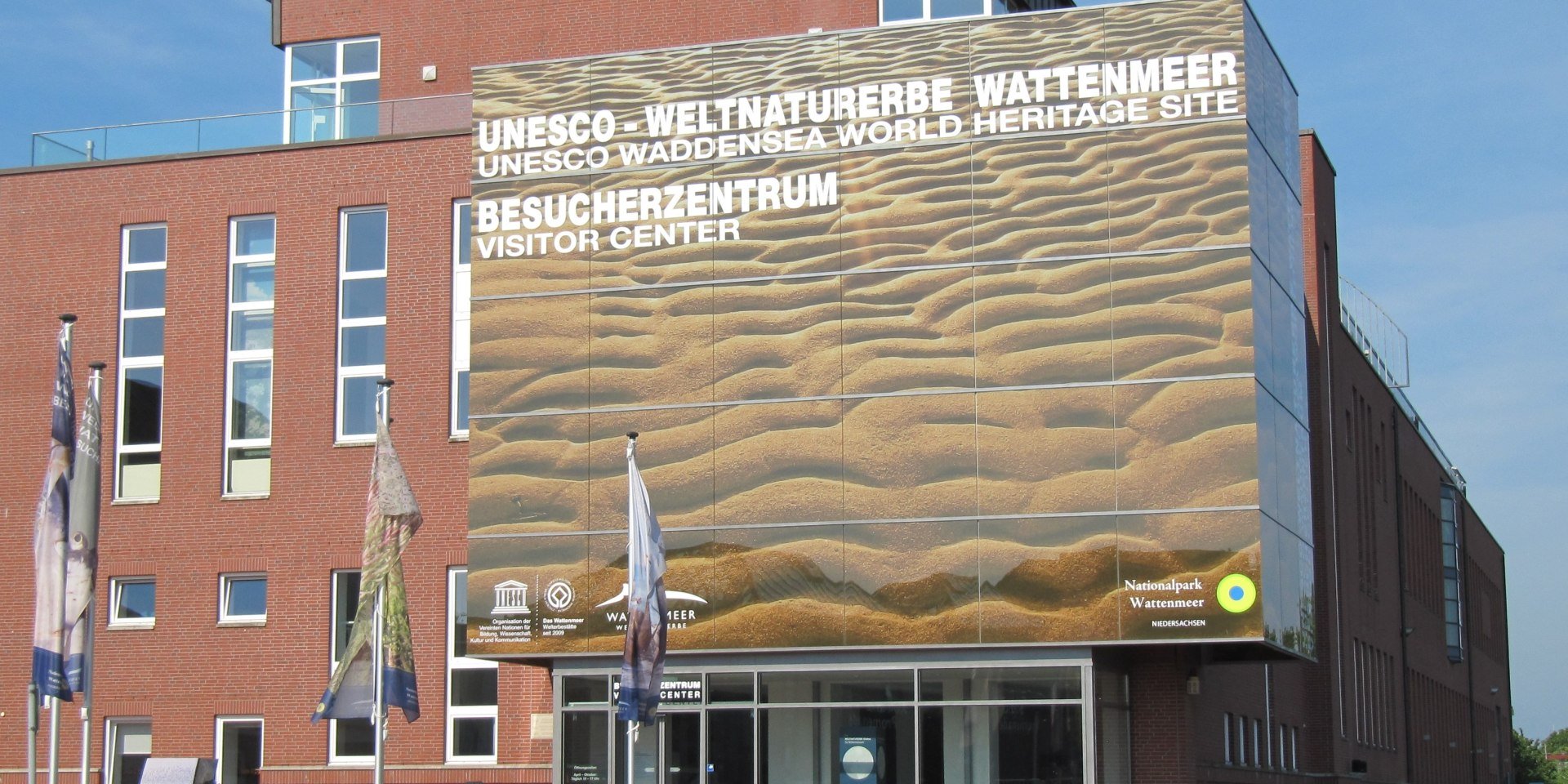Wattenmeer Besucherzentrum mit Walskulpturen aus Altmetall auf dem Vorplatz, © Panoramawand	Wattenmeer Besucherzentrum Wilhelmshaven/ Rene Spielmann