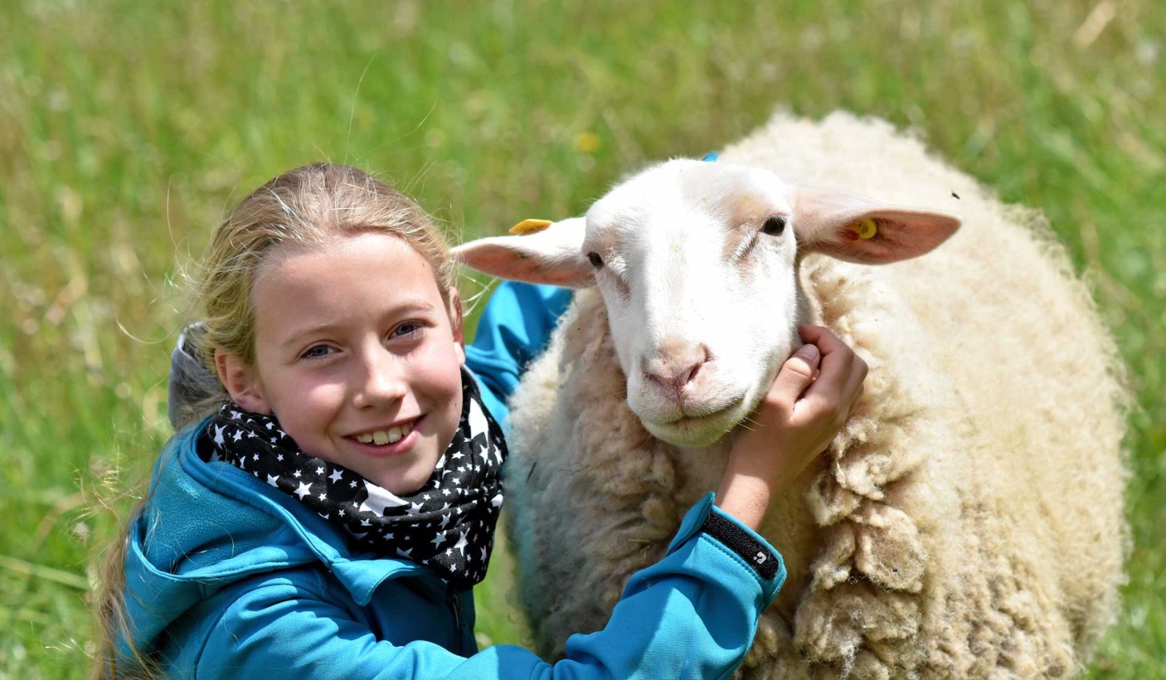 Ein Mädchen streichelt ein Schaf., © Heinz Sielmann Stiftung / Iris Blank