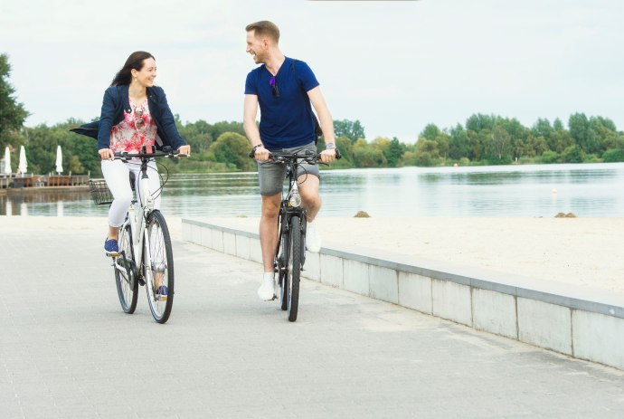 Zwei Radfahrer fahren auf der Promenade am Allersee Rad., © Wolfsburg AG / Jenko Sternberg
