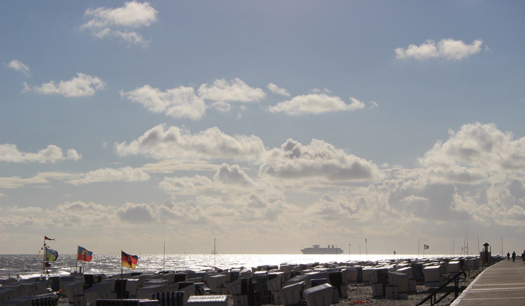 Blick über den Strand und das Meer. Am Horizont befindet sich ein Schiff., © Kurverwaltung Wangerooge