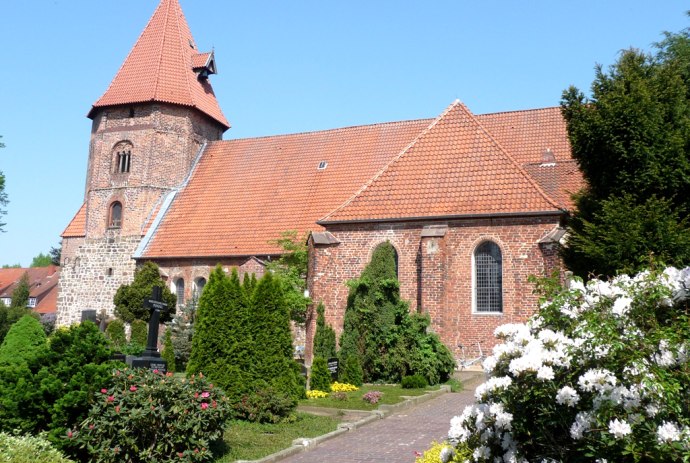 Die St. Laurentius-Kirche in Achim hinter dem schönen Garten mit den blühenden Blumen., © Mittelweser-Touristik GmbH