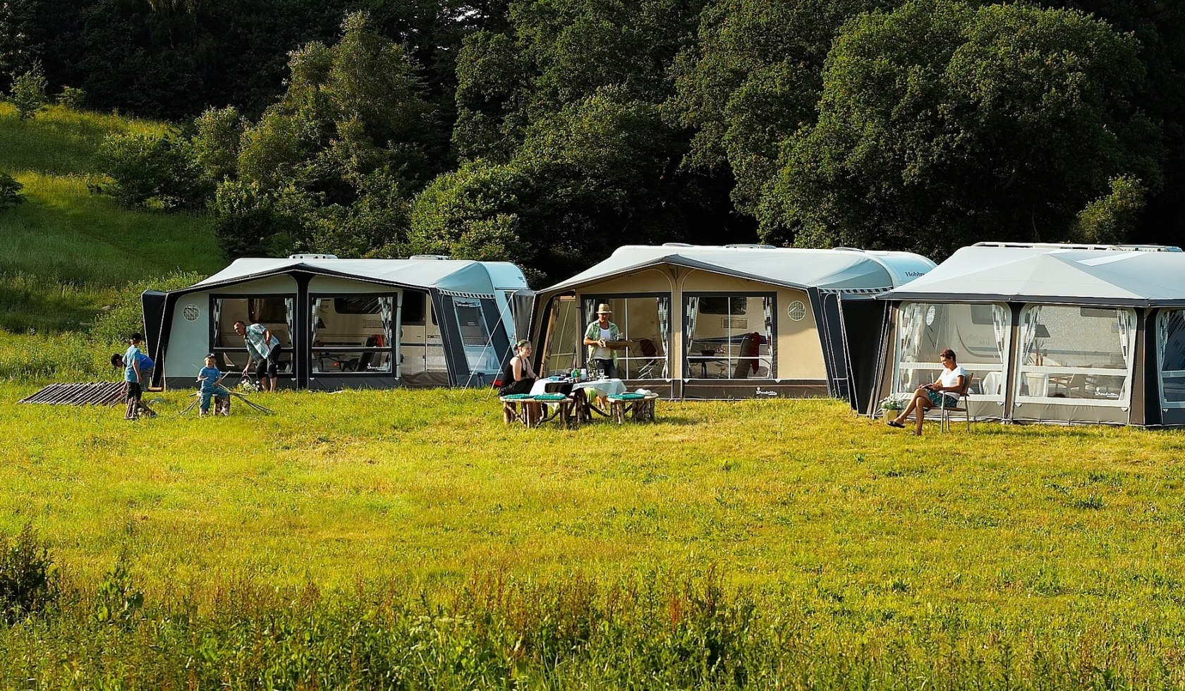 Drei Zelte stehen vor Wohnmobilen auf einem Campingplatz , © TMN/pixabay