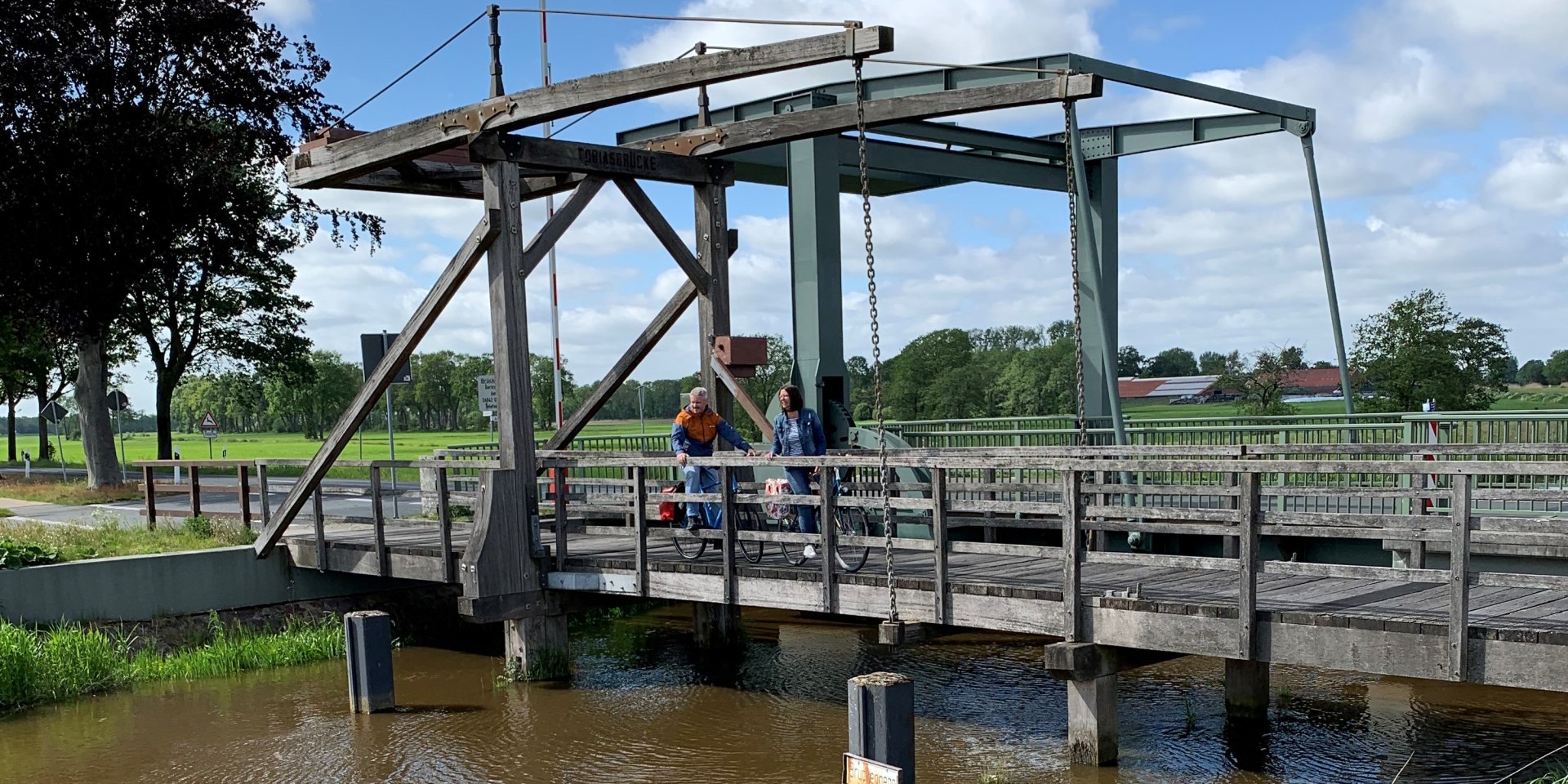 Zwei Radfahrer stehen auf einer Brücke in Ostfriesland, © Ostfriesland Tourismus GmbH