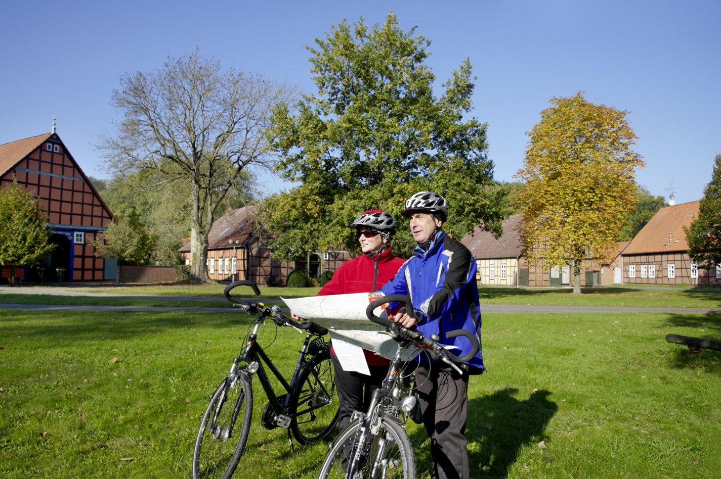 Zwei Radfahrer werfen einen Blick auf die Karte am Rundlingsdorf Lübeln., © MRH