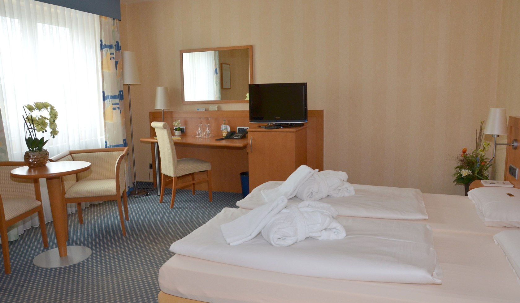 Blick ins Hotelzimmer im laVital mit Bett, TV, Sitzgelegenheit, © laVital Sport- & Wellnesshotel