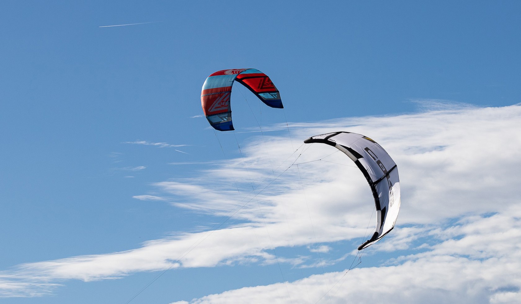 Zwei Kitebar in der Luft vor blauem Himmel.