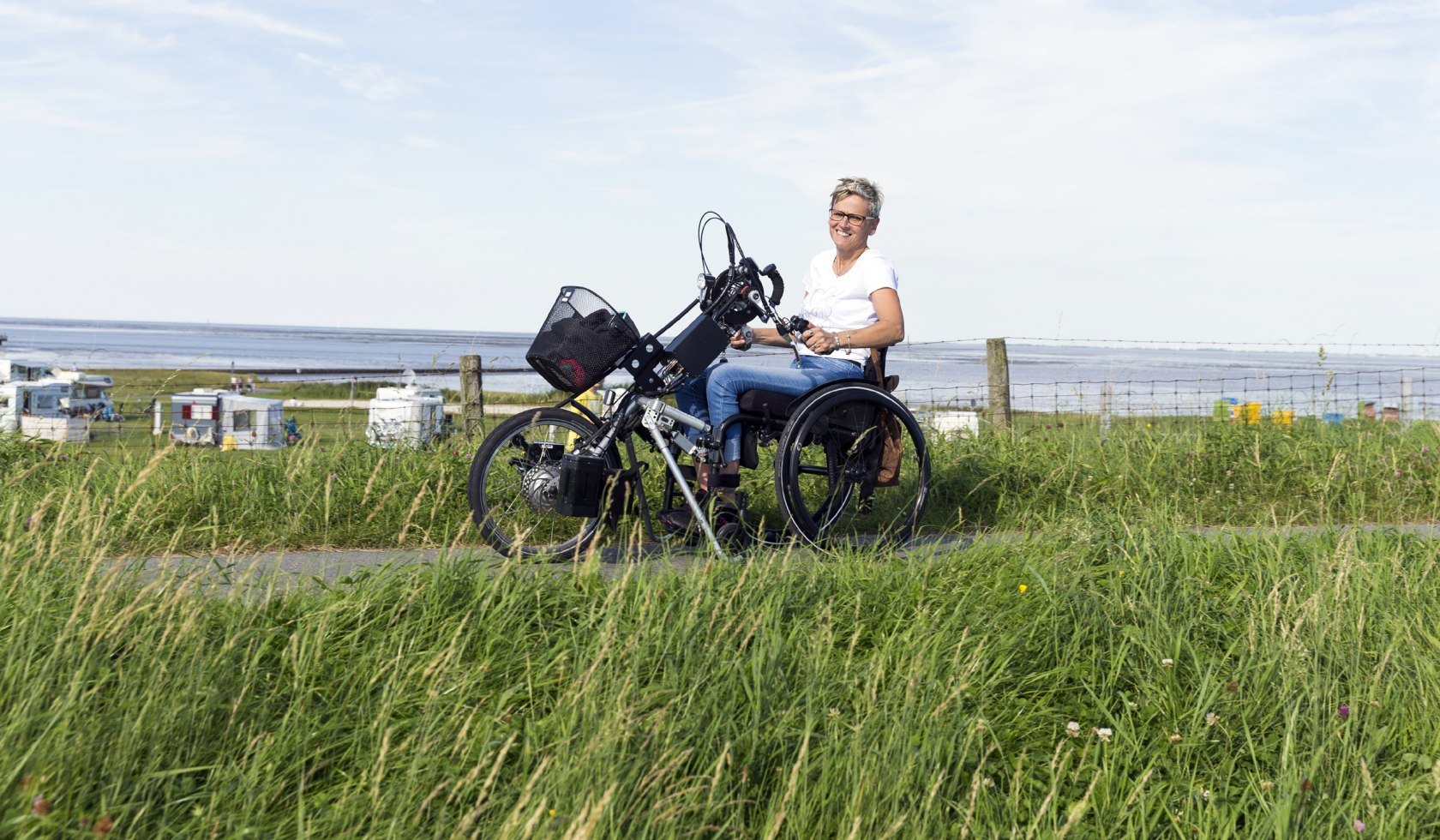 Frau mit Handbike auf der barrierefreien Strandpromenade, © Tourismus-Service Butjadingen GmbH &amp; Co. KG