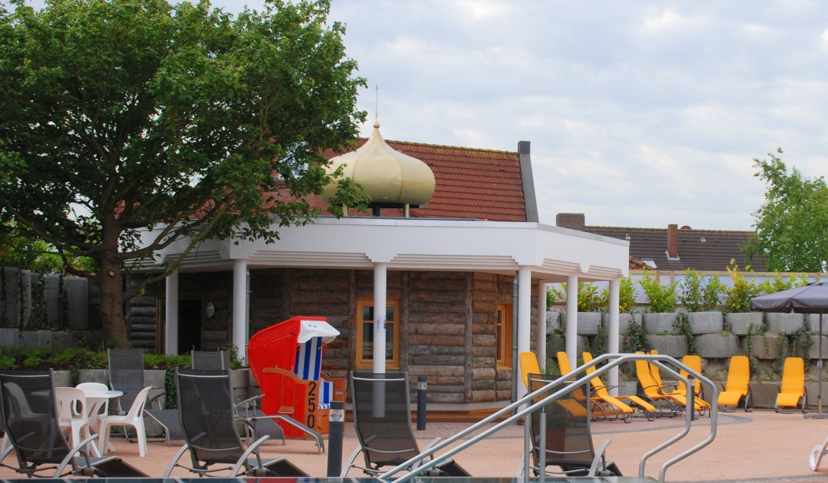 Banja-Sauna-Gebäude mit Liegen auf der Terrasse und Pool im Vordergrund, © Esens-Bensersiel Tourismus GmbH / Jürjens
