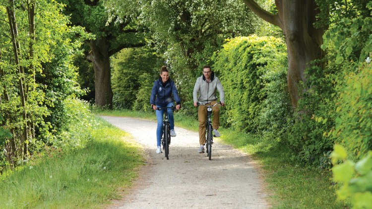 Zwei Radfahrer radeln auf Schotterweg im Naturpark Wildeshauser Geest, © Jörg Guhn