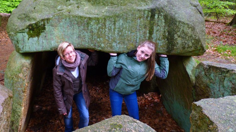 Die Grabkammer des Steinfelder Großsteingrabes wird entdeckt von zwei jungen Frauen., © Touristikverband Landkreis Rotenburg (Wümme)  e.V. / Udo Fischer