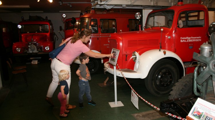 Mutter zeigt zwei Kindern ein Feuerwehrauto, © Feuerwehrmuseum Salzbergen / Marcus Droste