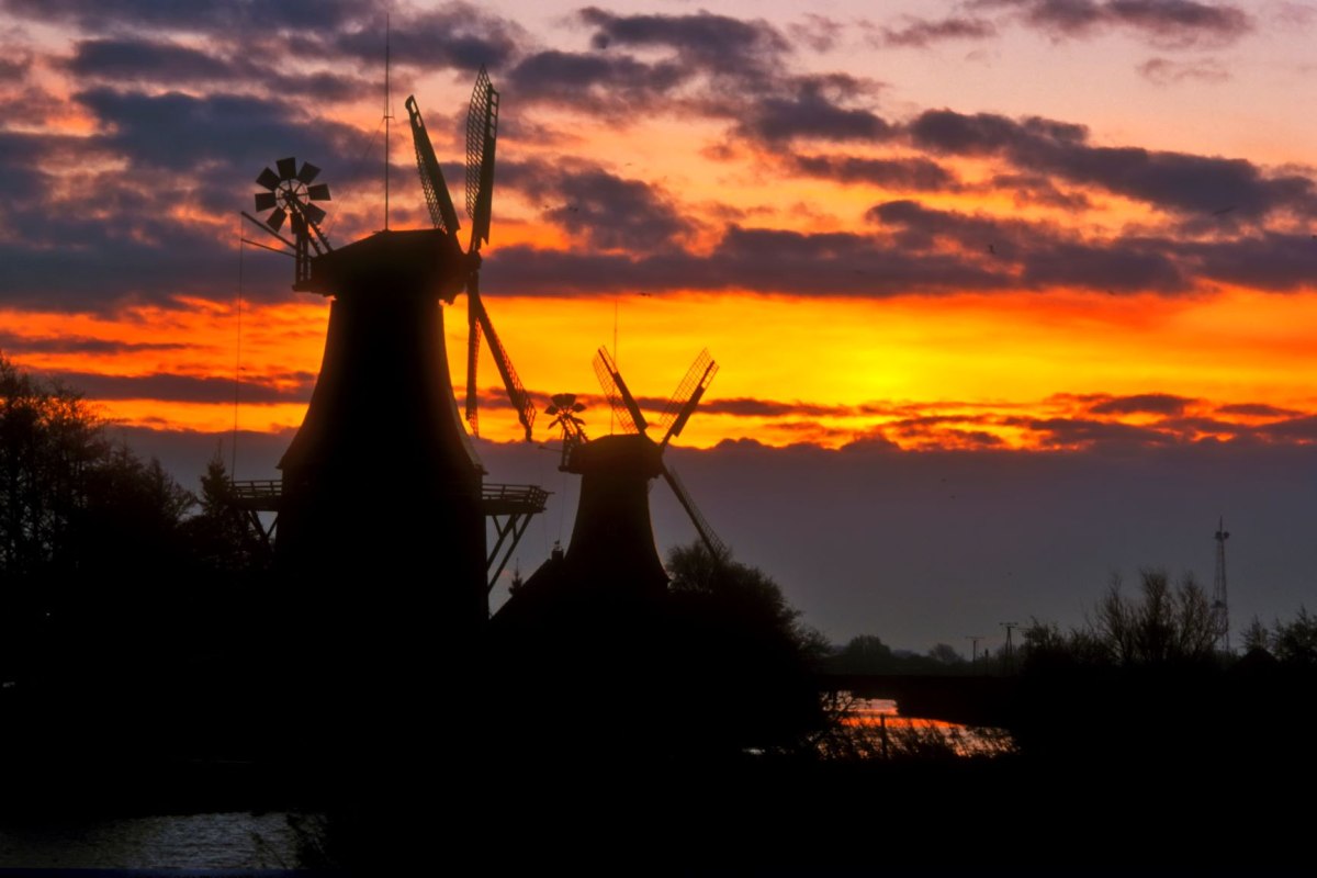 Die Zwillingsmühlen von Greetsiel am alten Greetsieler Sieltief sind ein Wahrzeichen des beliebten Ortes an der Nordseeküste, © Dieter Schinner