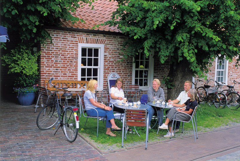 Gruppe Fahrradfahrer macht Pause im Gasthof, © Ostfriesland Touristik - Landkreis Aurich GmbH