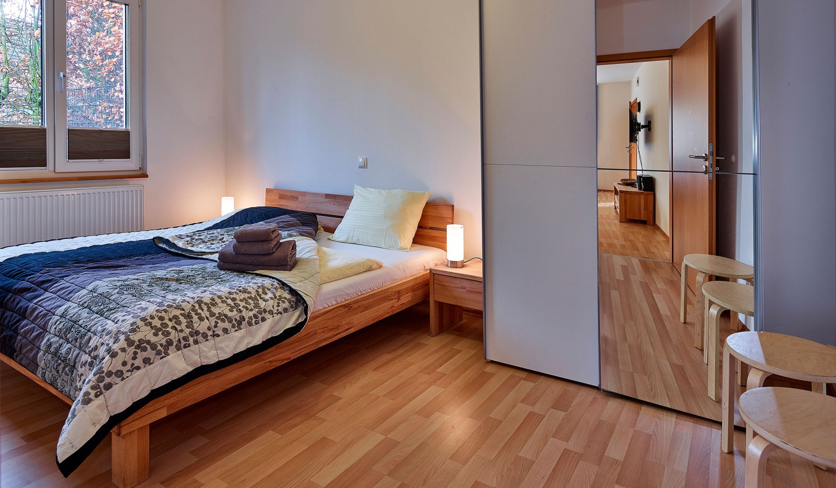 Einblick in das Schlafzimmer mit Doppelbett, Schrank und Holzfußboden, © Tierpark Nordhorn gGmbH / Franz Frieling