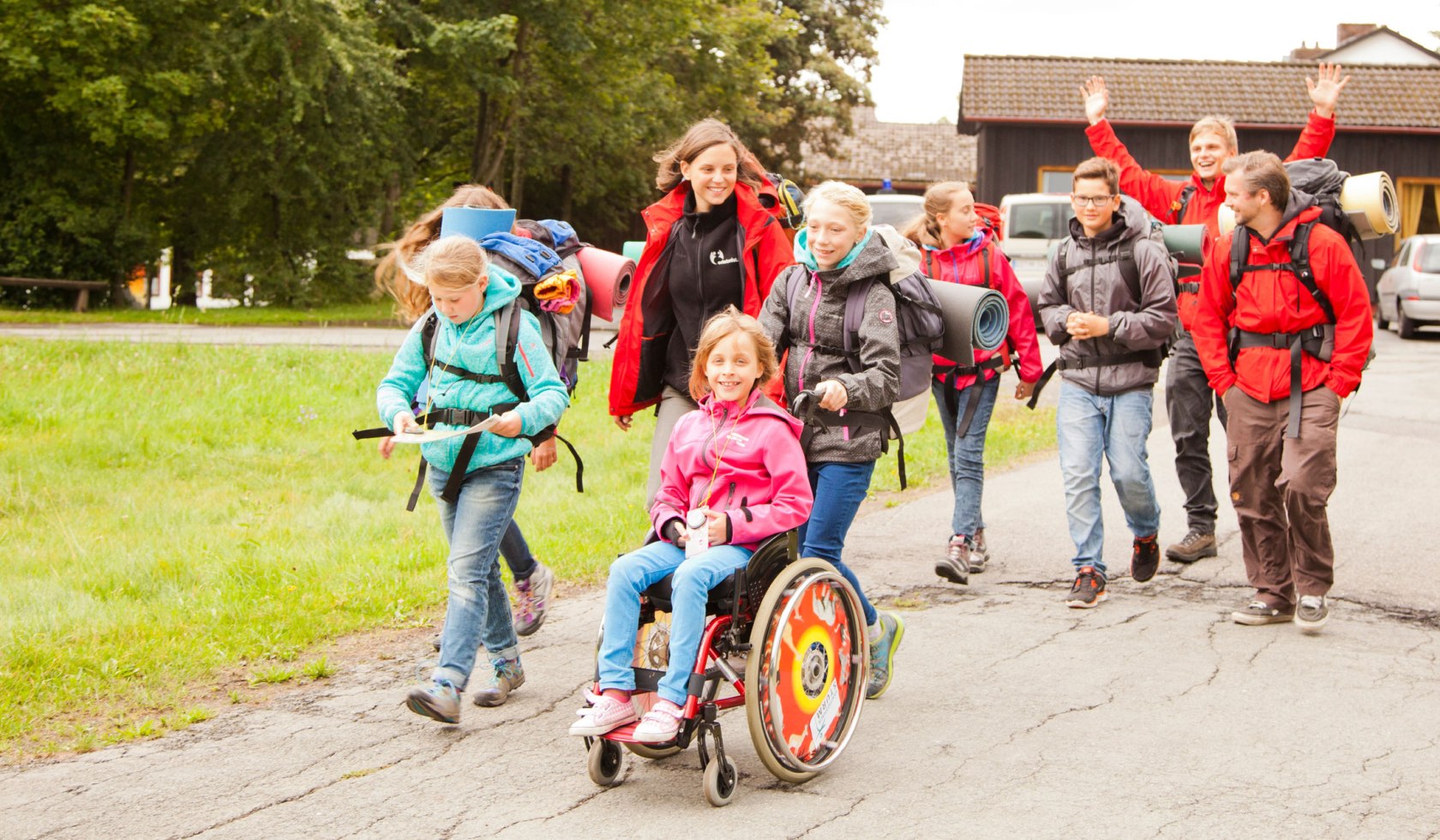 Kinder und Erwachsene machen einen Tour durch den Harz. Ein Mädchen sitzt im Rollstuhl und lächelt., © erlebnistage Harz / Markus Hennemann