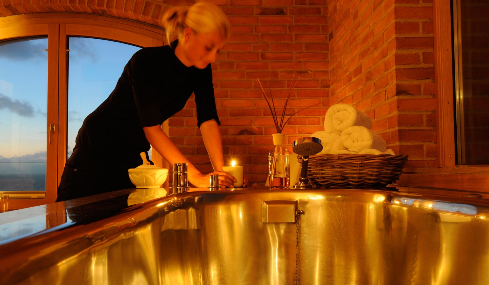 Frau richtet Badewanne im Kerzenlicht an, © Hotel Seesteg Norderney
