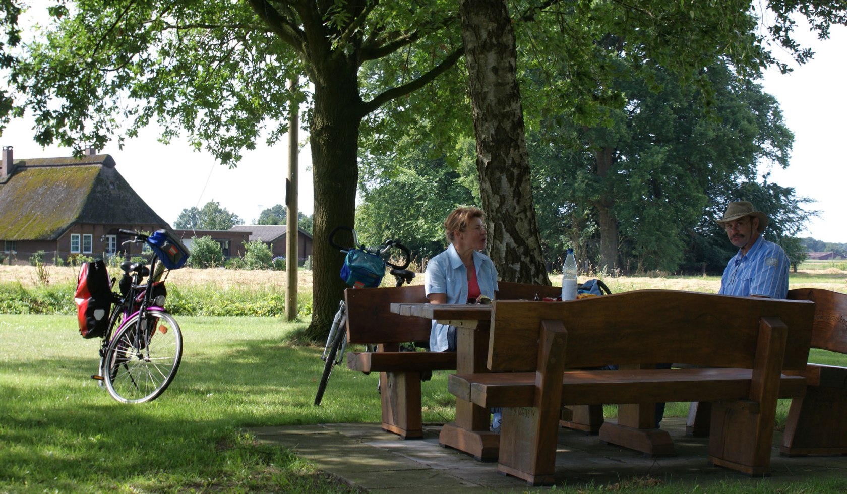 Radfahrer machen eine Pause in der Natur auf iner Bank mit einem Tisch., © Naturpark Wildeshauser Geest/ Jörg Guhn