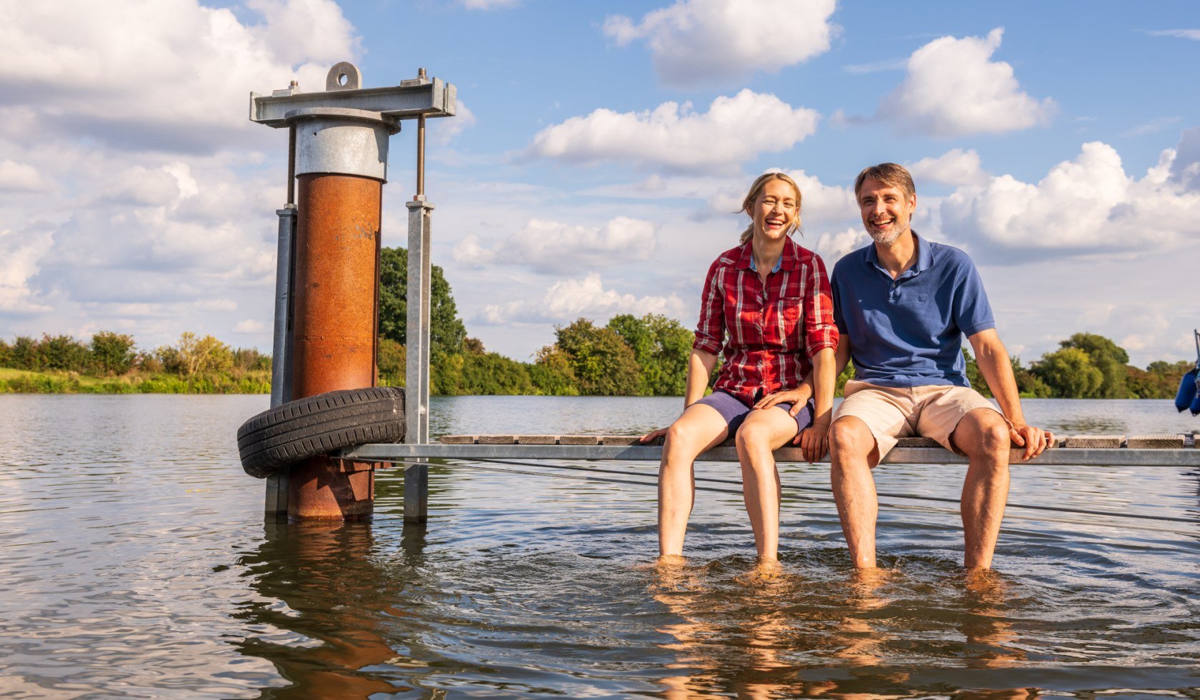 ein glückliches Paar sitzt auf einem Bootssteg an der Weser , © TMN/Markus Tiemann