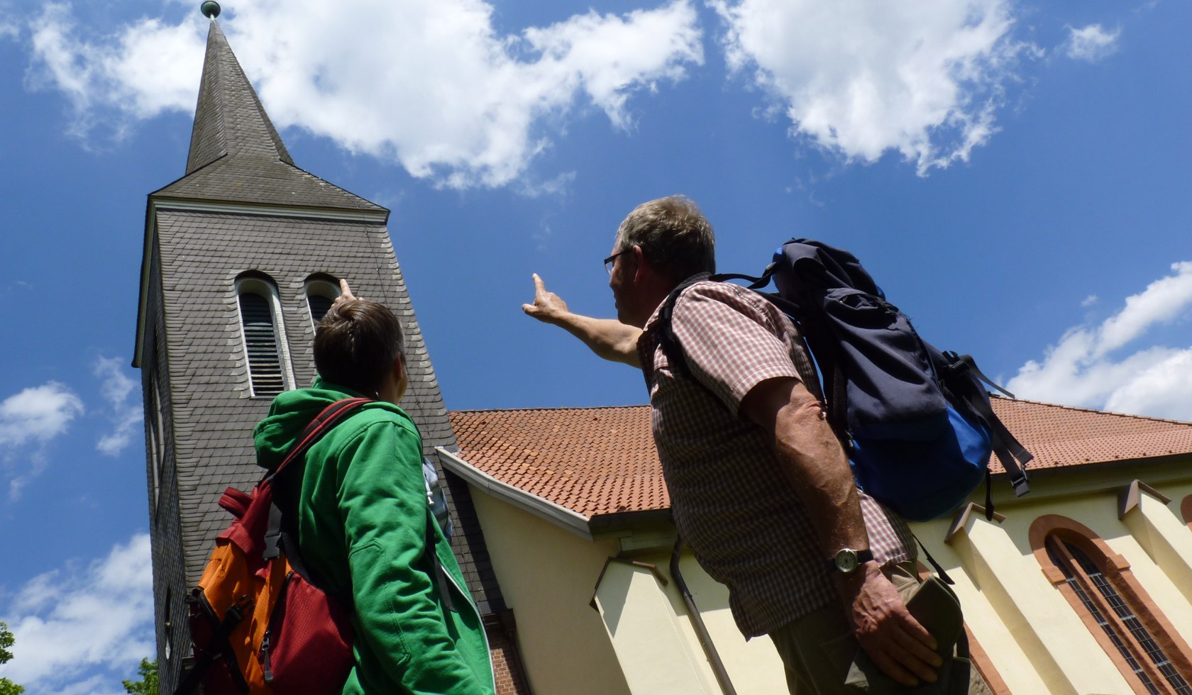 Wandere zeigen auf die hohe Kirche in Kirchtimke., © TouROW