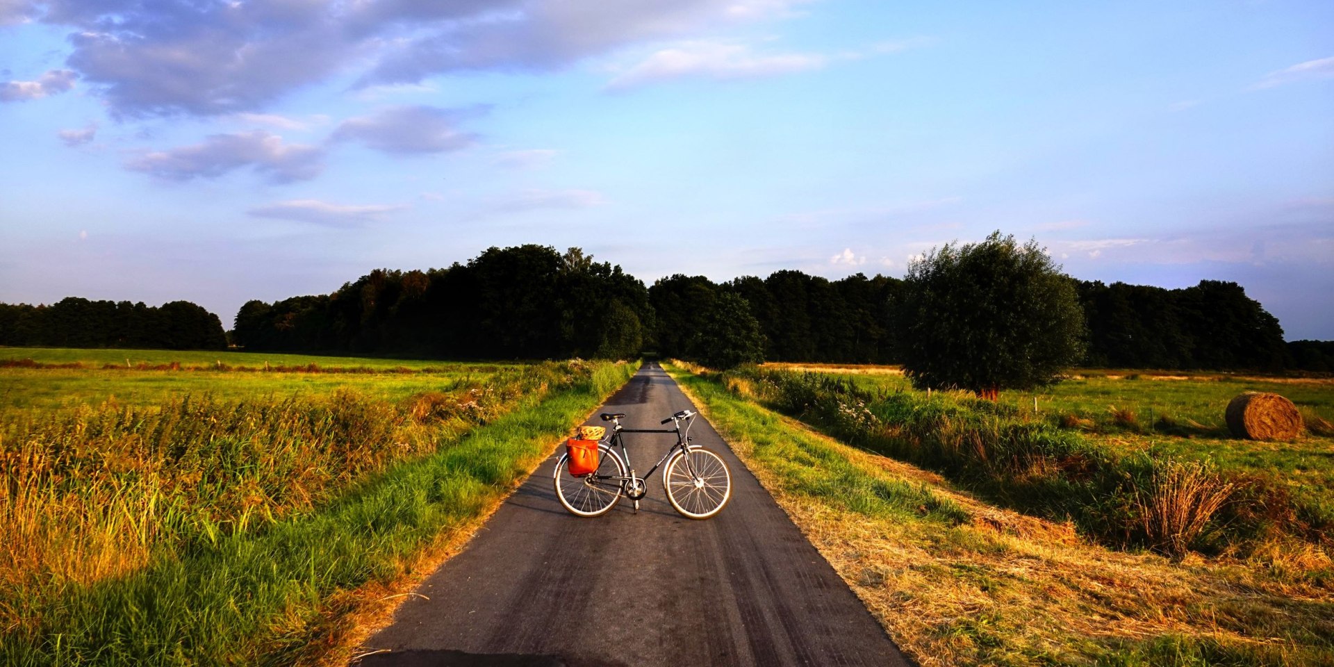 Fahrrad auf Weg zwischen Feldern beim Sonnenuntergang, © Robert Wenzel