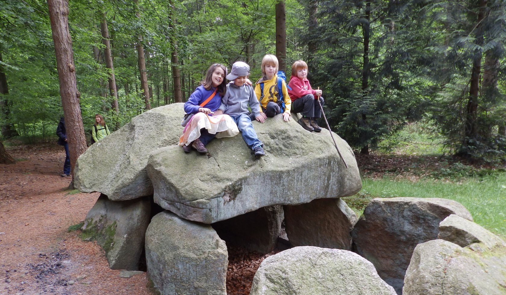 Vier Kinder rasten auf großen Steinen am Wegesrand., © Touristikverband Landkreis Rotenburg (Wümme)  e.V. / Udo Fischer