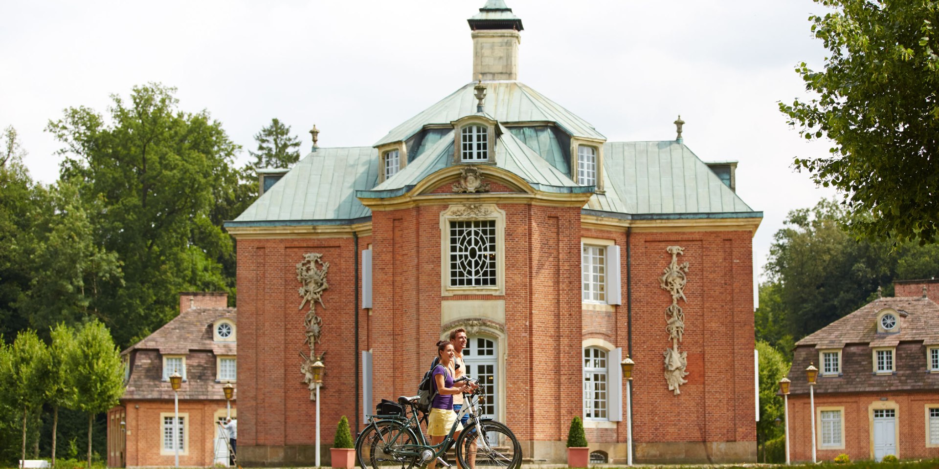 Zwei Radfahrer vor dem Schloss Clemenswerth, © Emsland Touristik