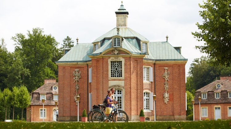 Zwei Radfahrer vor dem Schloss Clemenswerth, © Emsland Touristik