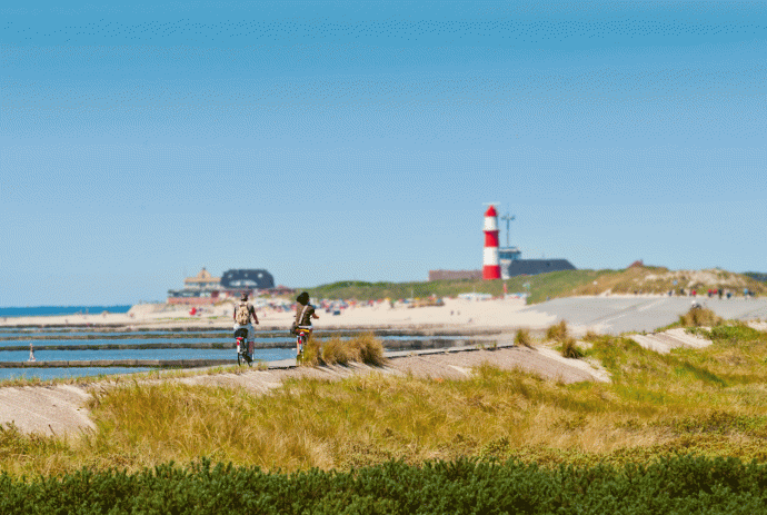 Zwei Radfahrer fahren auf ihren Fahrrädern entlang der Nordsee auf Borkum., © Int. Dollard Route e.V. / Gerd Kaja